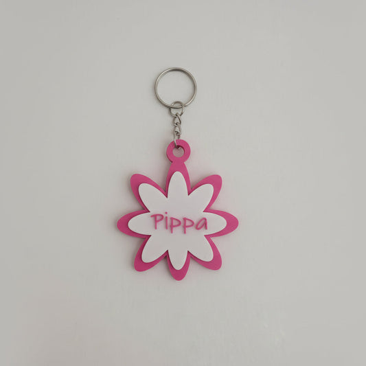 Pink flower-shaped keychain with 'Pippa' on a white background