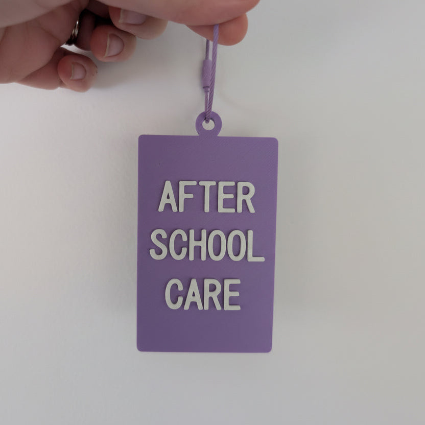 Purple tag with 'After School Care' text held by a hand against a white background