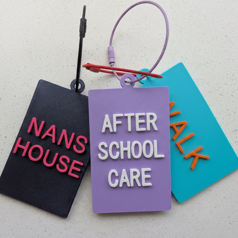 Colorful luggage tags with text on a textured surface
