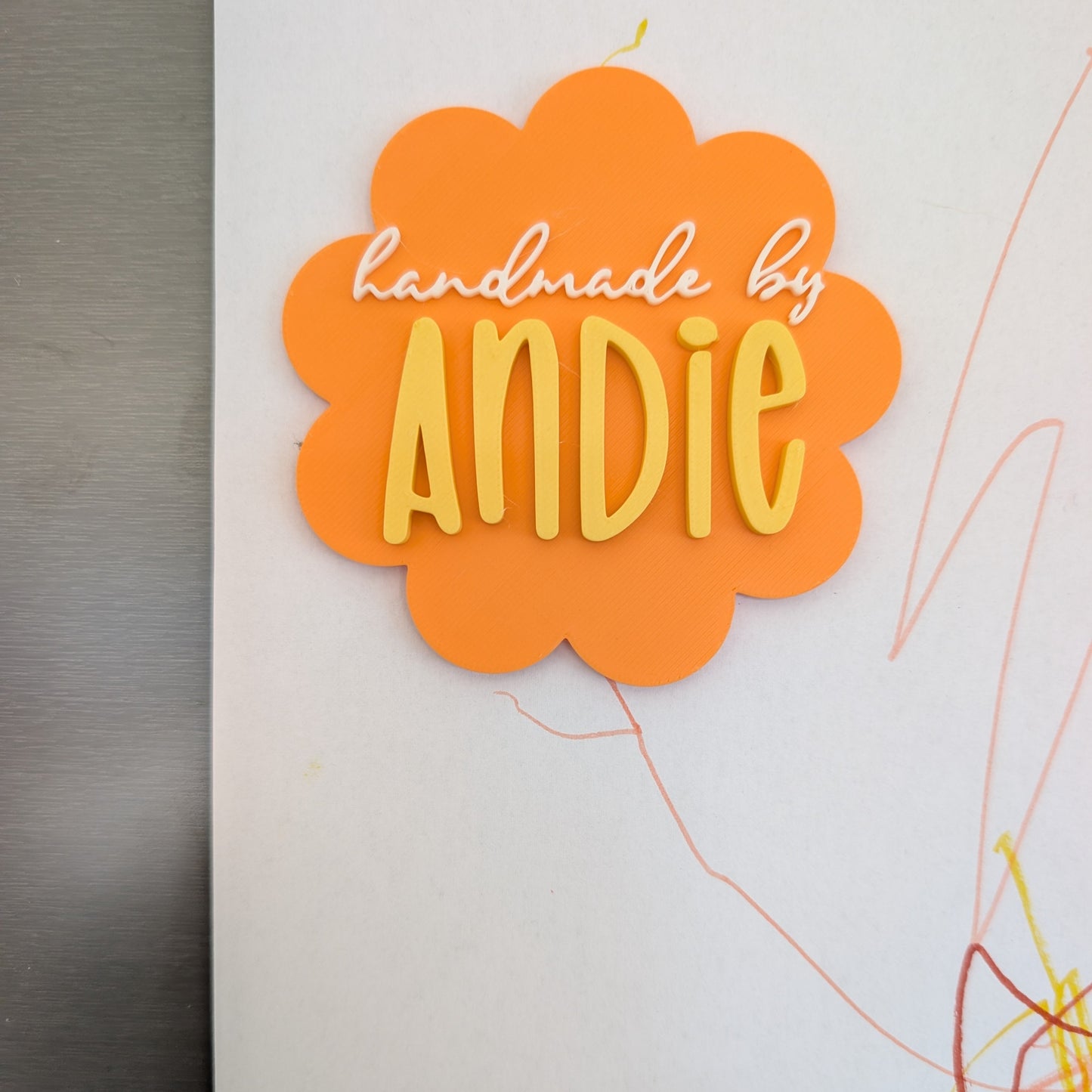 Orange cloud-shaped magnet with 'handmade by ANDIE' text on a white background