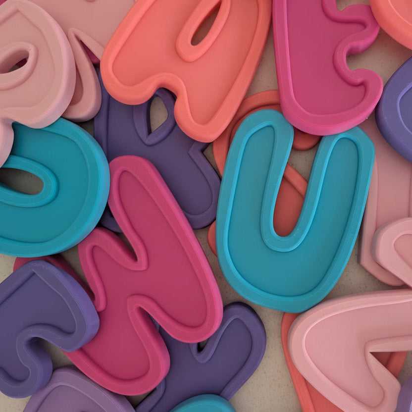 Colorful plastic letters scattered on a textured surface