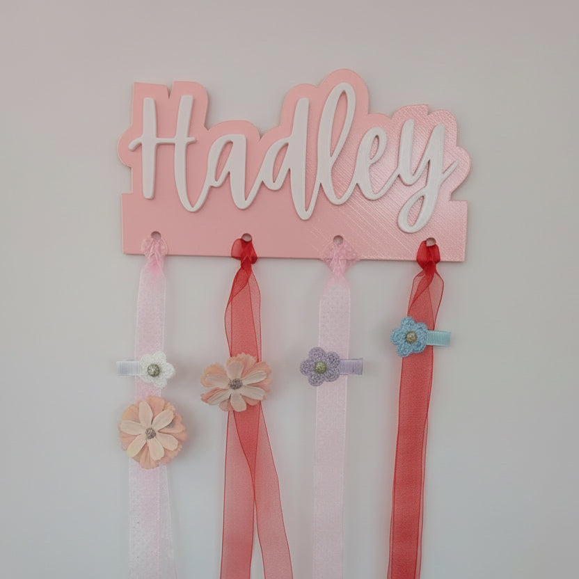 Pink nameplate with ribbons and flowers on a white background